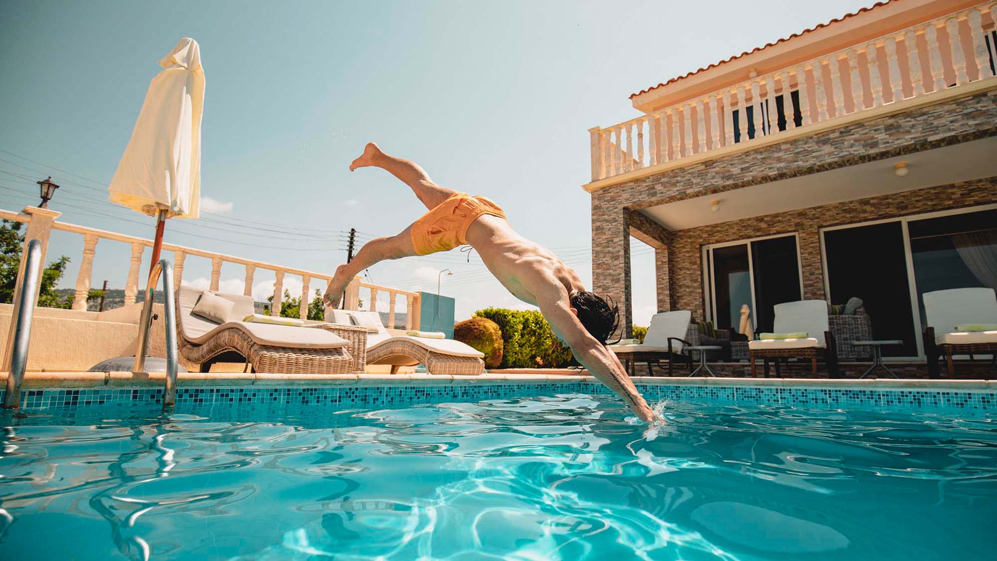 Kille som dyker ner i en pool på Cypern